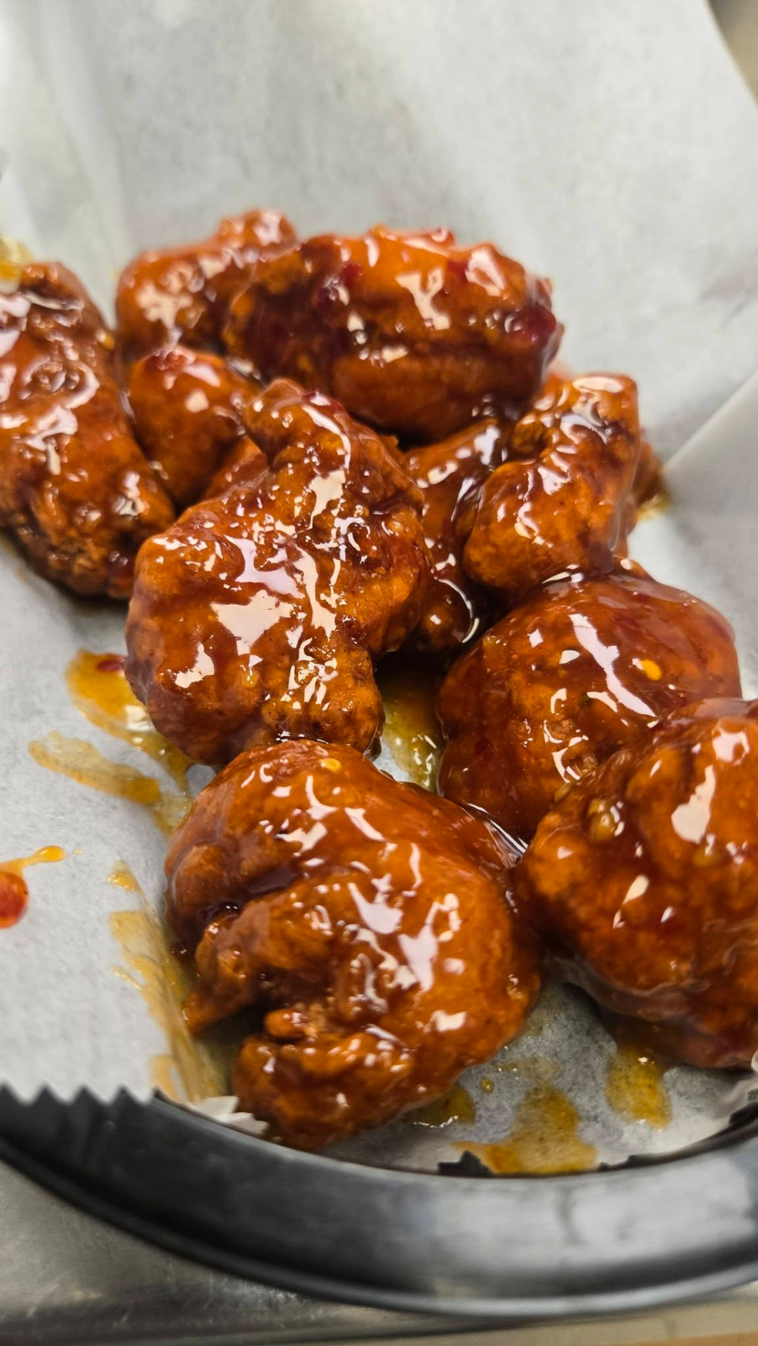 Boneless wings in a dark red glazed sauce