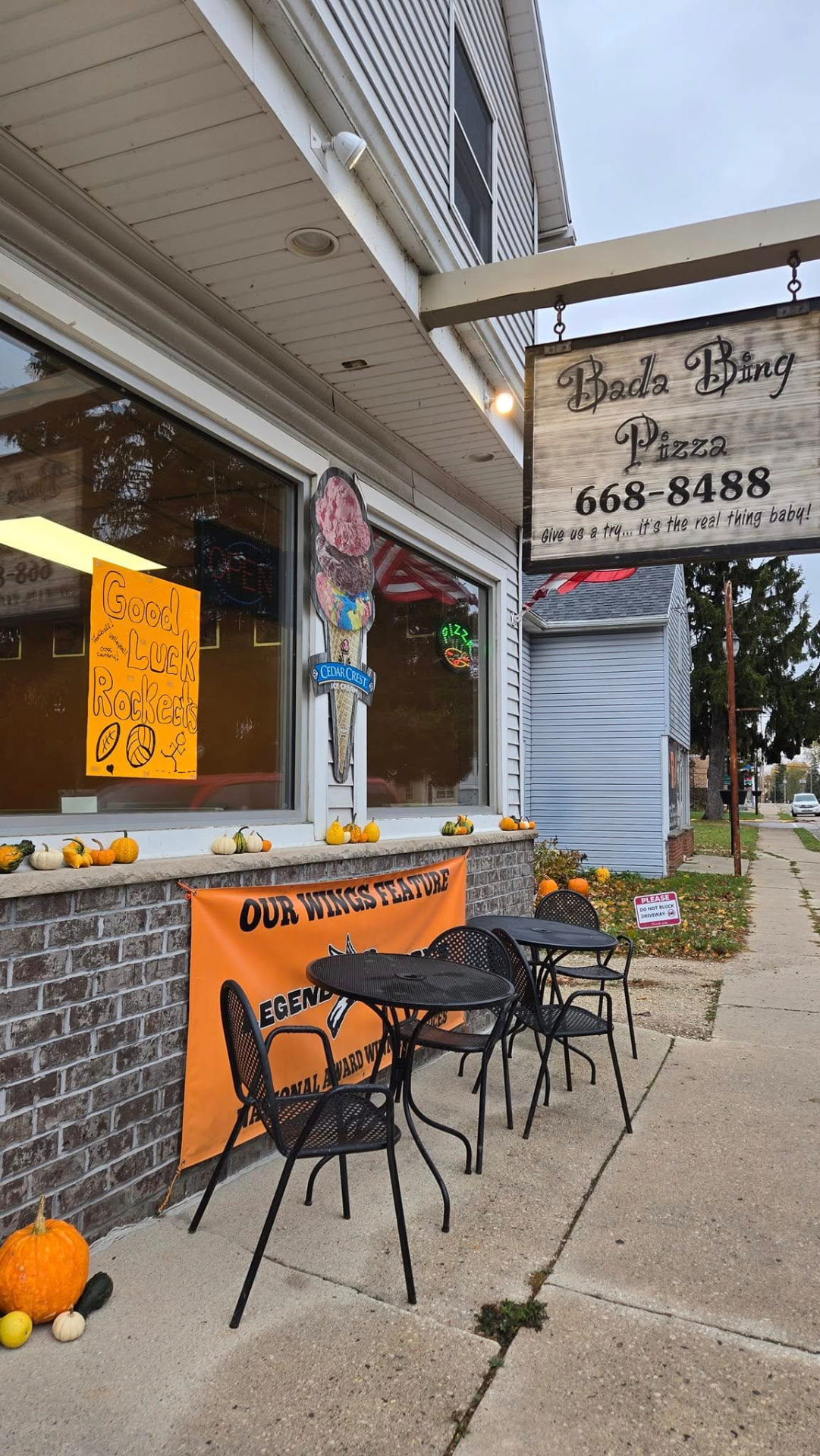 Angled view of the Bada Bing Pizza storefront and sidewalk seating in Cedar Grove